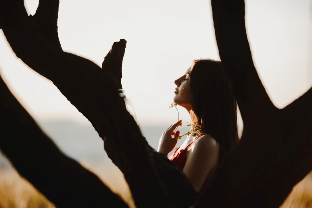 Framed by tree branches, a woman.