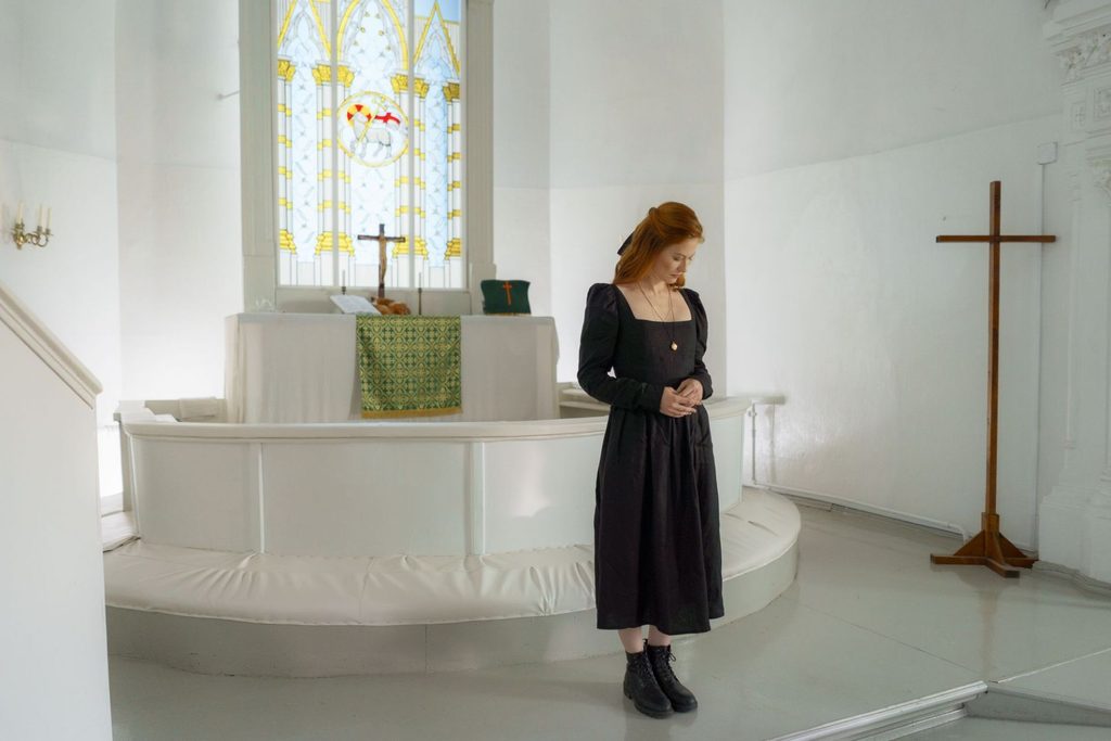 Woman standing inside a church.